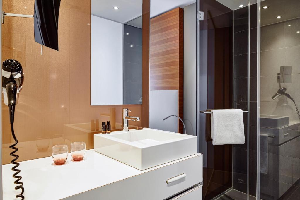 a bathroom with a white sink and a shower at LÉGÈRE HOTEL Luxembourg in Luxembourg