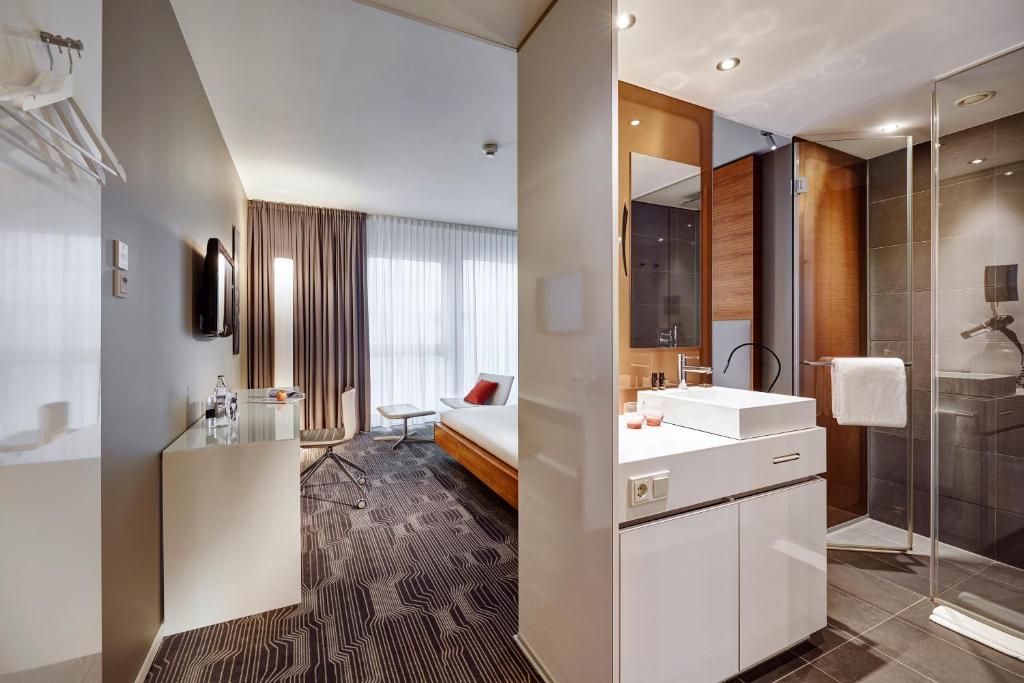 a bathroom with a white sink and a shower at LÉGÈRE HOTEL Luxembourg in Luxembourg
