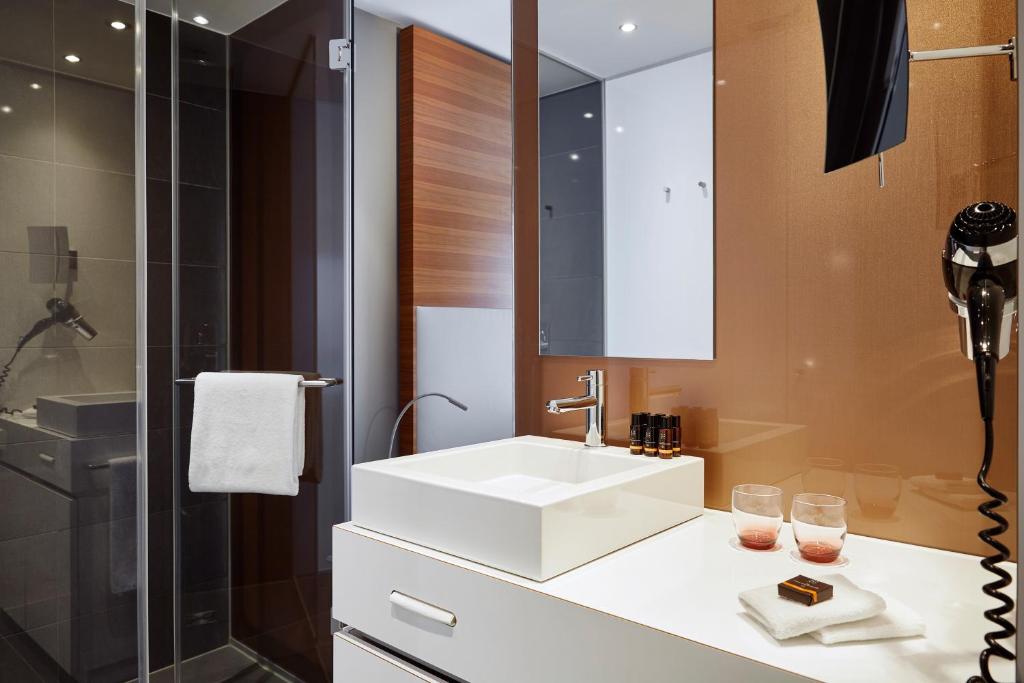 a bathroom with a white sink and a shower at LÉGÈRE HOTEL Luxembourg in Luxembourg