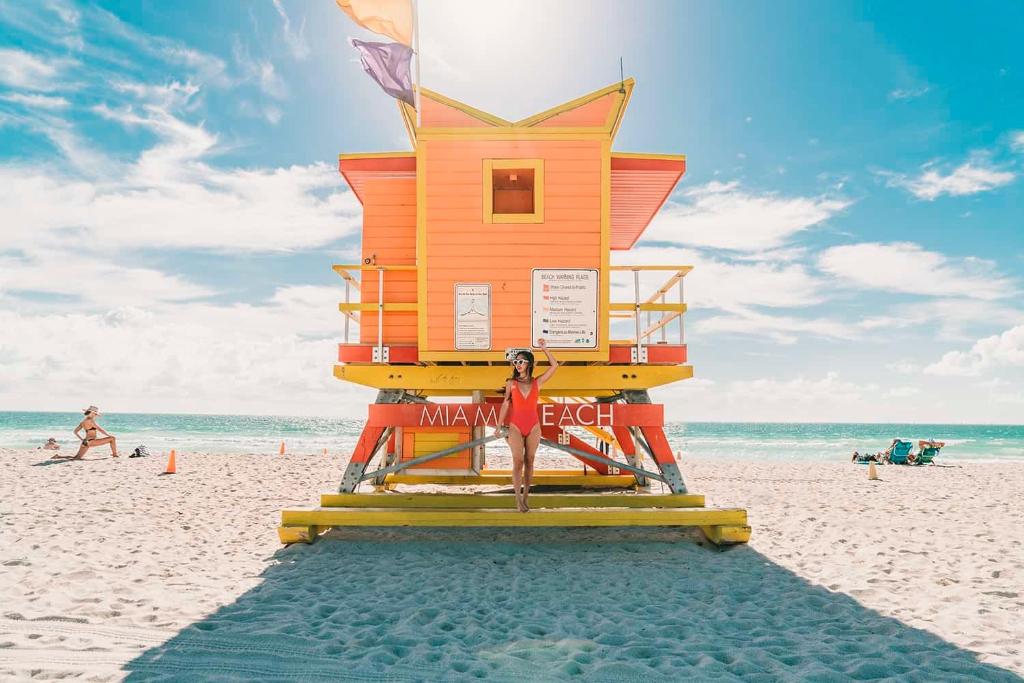 einen Rettungsturm am Strand mit einer Frau vor der Tür in der Unterkunft 1 bedroom in the BEST location in South Beach ! in Miami Beach
