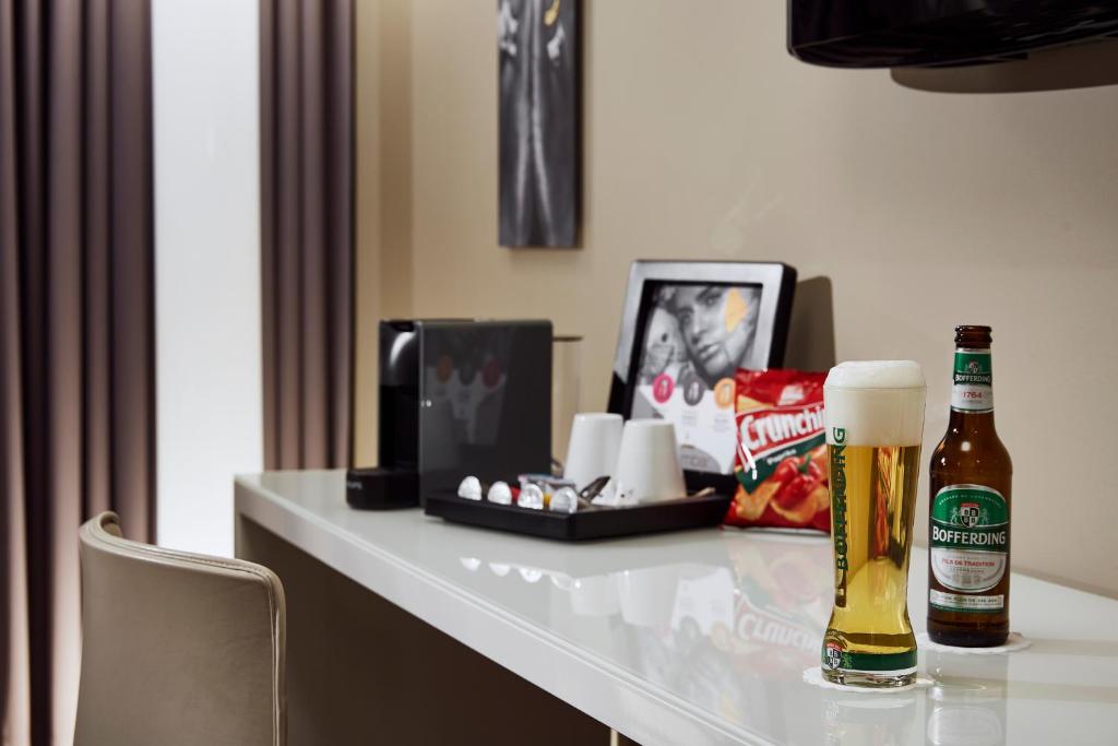 a table with a bottle of beer and a tray of snacks at LÉGÈRE HOTEL Luxembourg in Luxembourg