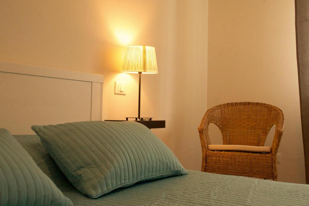 ein Schlafzimmer mit einem Bett mit einer Lampe und einem Stuhl in der Unterkunft B&B Casa Bologna in Bologna