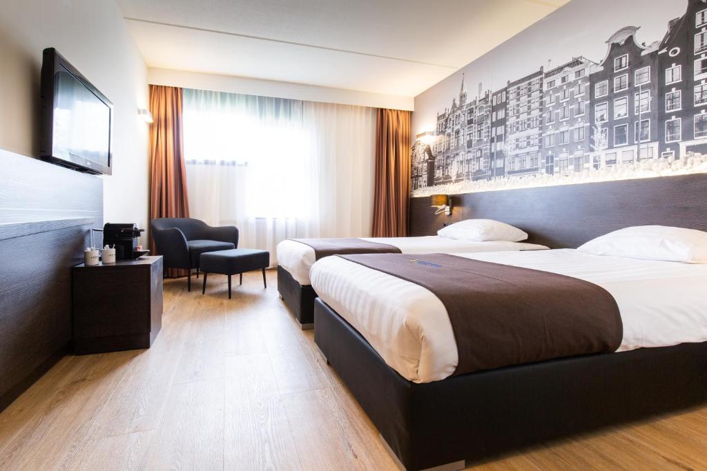 een hotelkamer met 2 bedden en een televisie bij Bastion Hotel Amsterdam Noord in Amsterdam