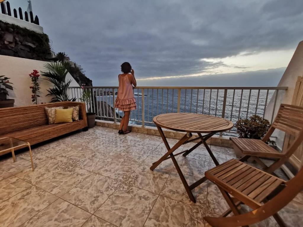 a woman standing on a balcony looking at the ocean at Ocean Wave by TOR in Puerto de la Cruz