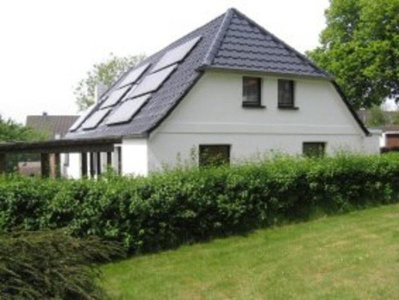 a white house with a roof with solar panels on it at Ferienwohnung Angelika und Guenter in Handewitt