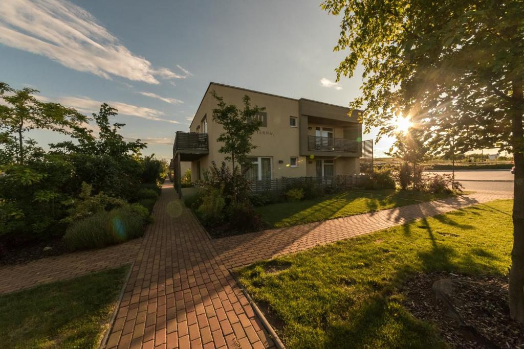 a house with a brick walkway in front of it at Hotel Termal Mušov in Pasohlávky