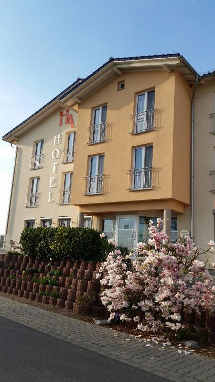 ein großes Gebäude mit Blumen davor in der Unterkunft Hotel Ackermann in Riedstadt