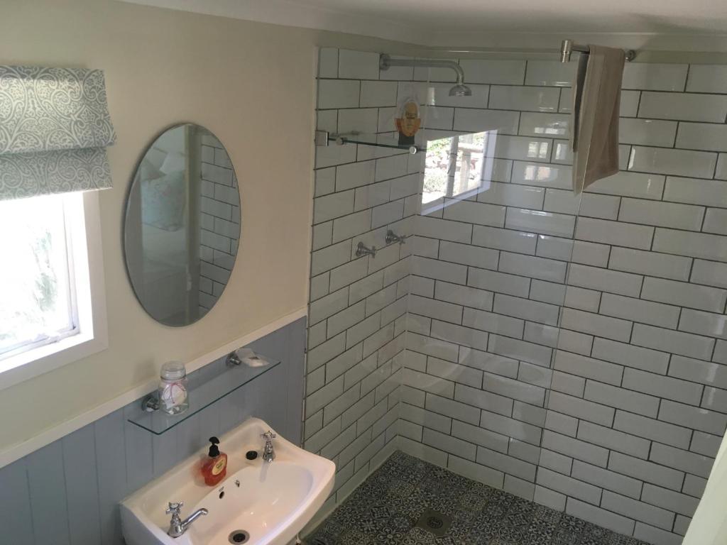 een badkamer met een wastafel en een spiegel bij Cheverells Farm in Grabouw