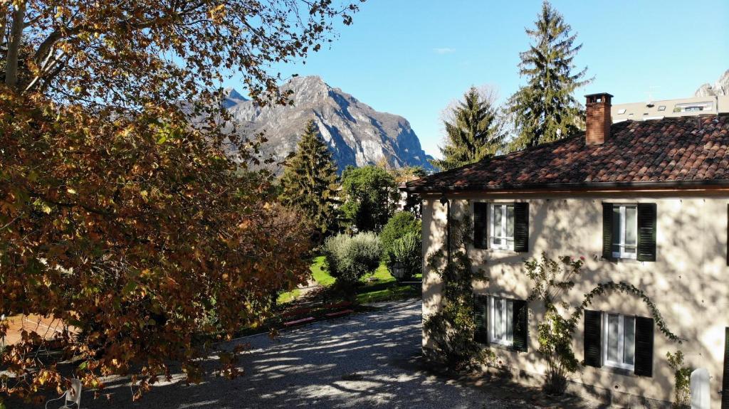 a stone house with a mountain in the background at La Casa nel Parco Lecco in Lecco