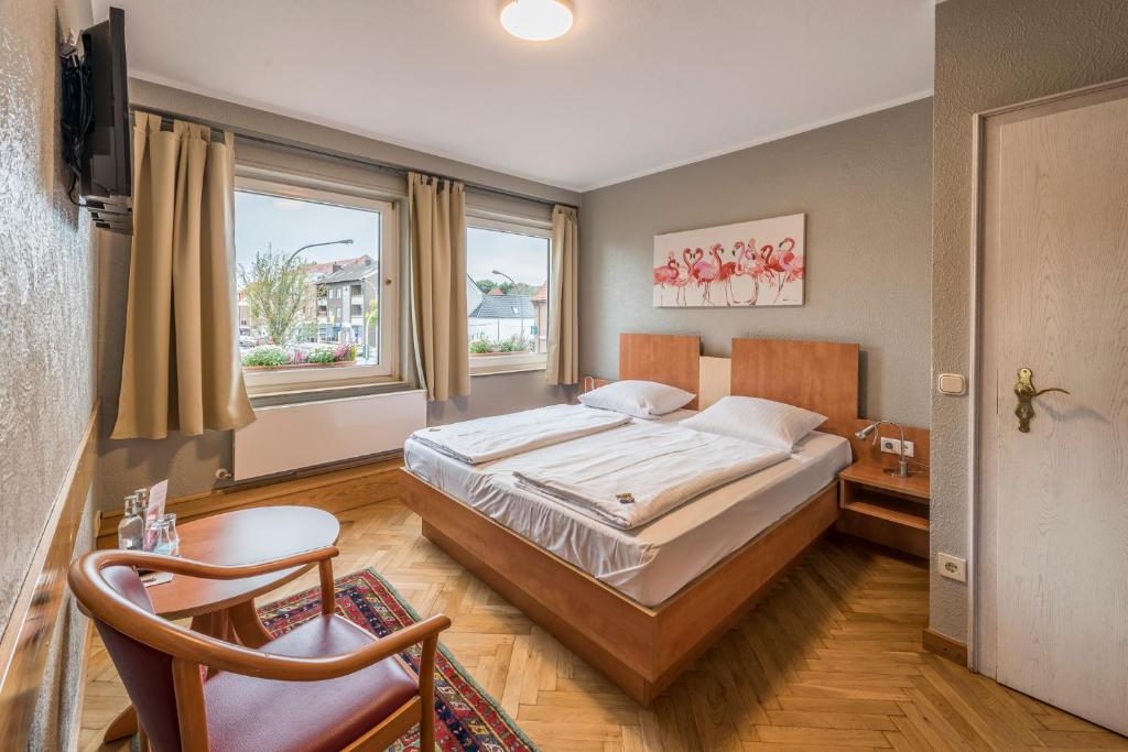 a bedroom with a large bed and a window at Hotel Hiltruper Hof in Münster