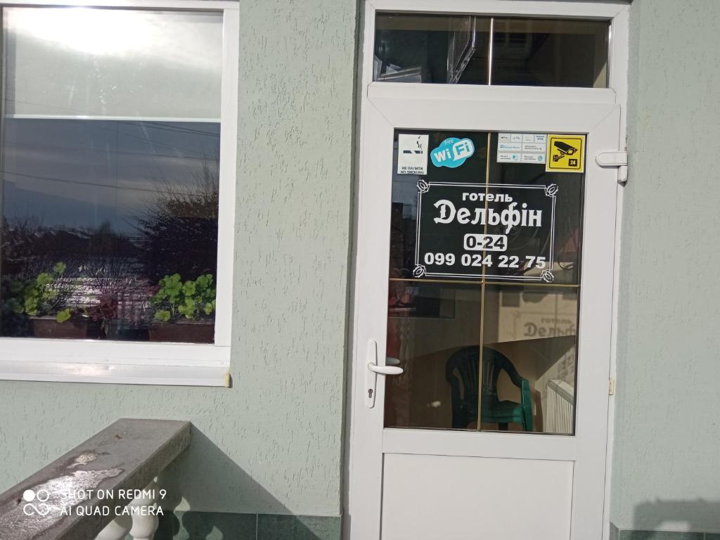 a sign is on the door of a store at Hotel Delfin in Mukacheve