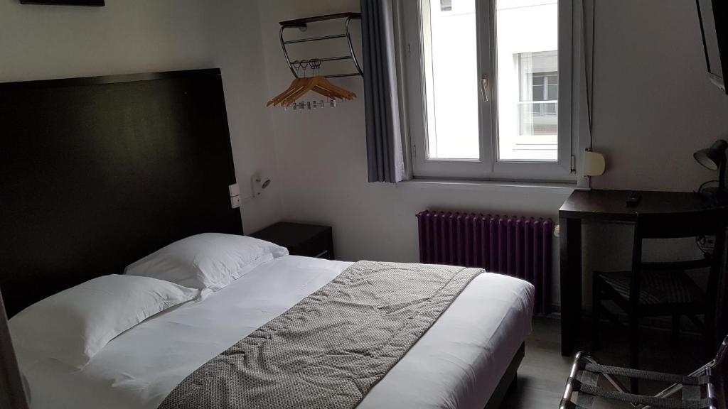 a bedroom with a bed and a window and a desk at Au Spatial in Amiens