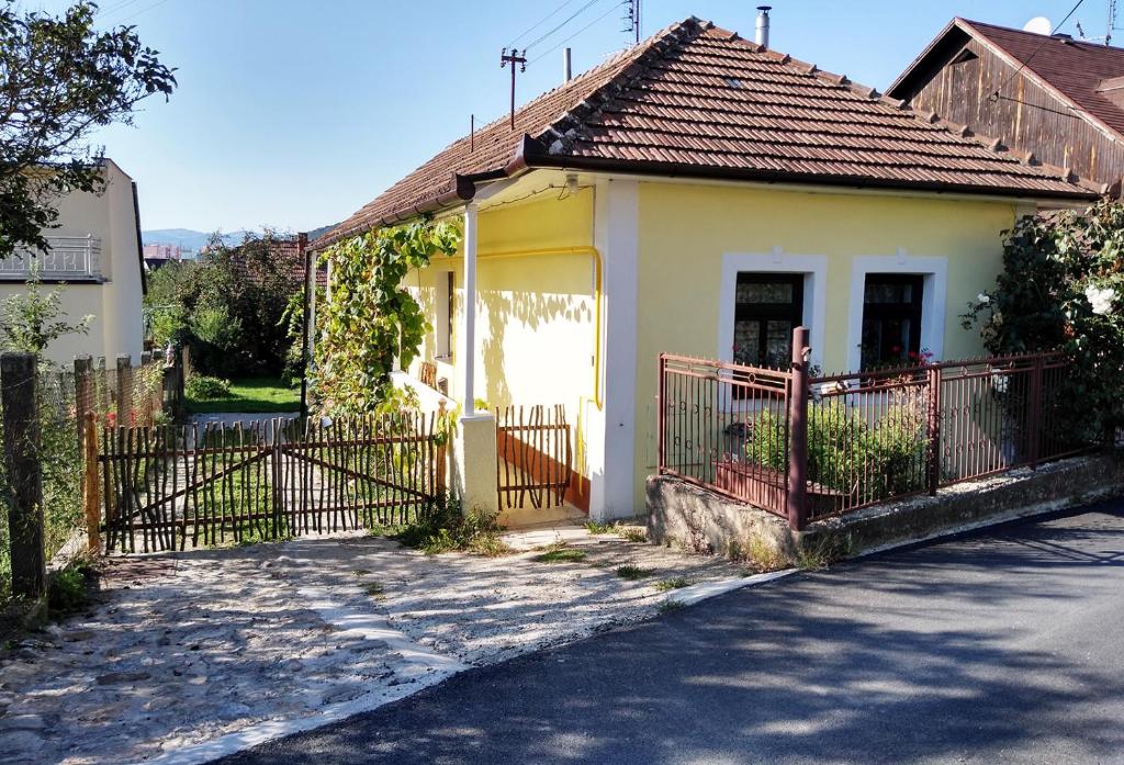 ein kleines Haus mit einem Tor und einem Zaun in der Unterkunft Lately renovated country house in Trenčín