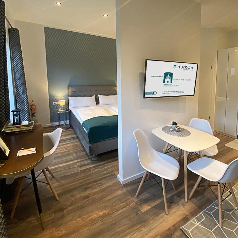 a hotel room with a bed and a table and chairs at Nurban Apartments Oldtown in Nürnberg