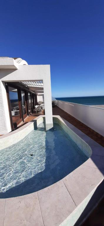 une piscine devant une maison avec l'océan dans l'établissement PORT CIPRIANO Sur les toits , vue panoramique sur la mer, à Saint-Cyprien