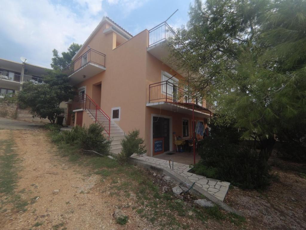 une maison avec un balcon sur le côté de celle-ci dans l'établissement Apartments Jere, à Primošten