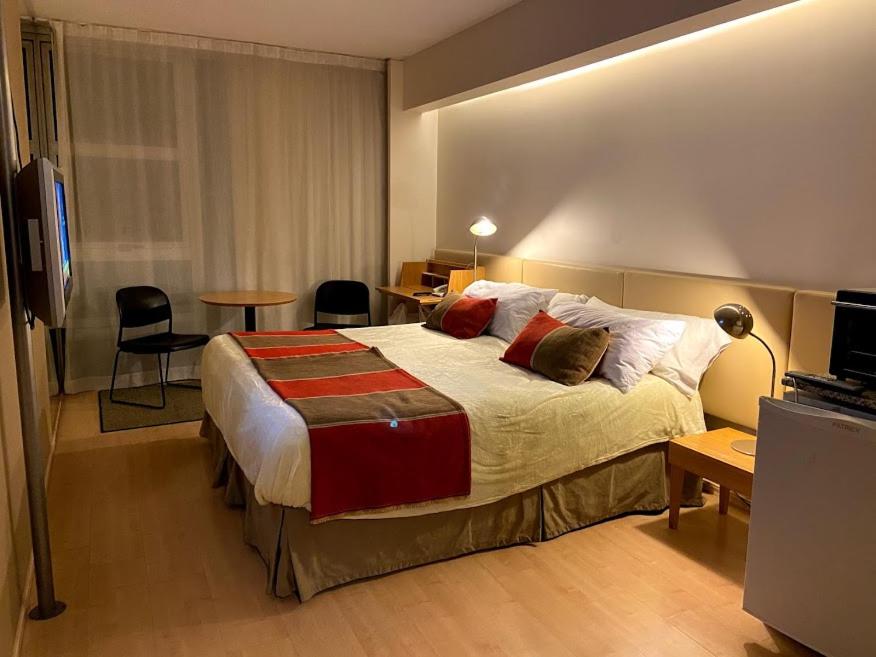 a hotel room with a bed and a table and chairs at Recoleta Apartment in Buenos Aires