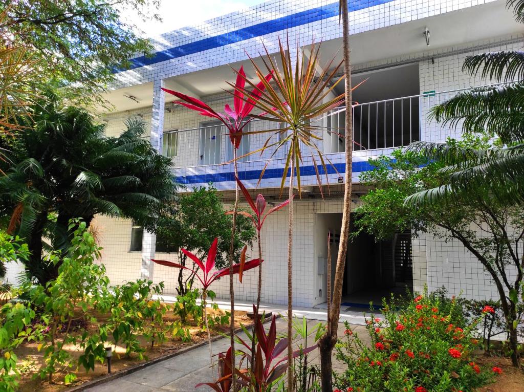 Un bâtiment avec beaucoup de plantes devant lui dans l'établissement Pousada Cecosne, à Récife