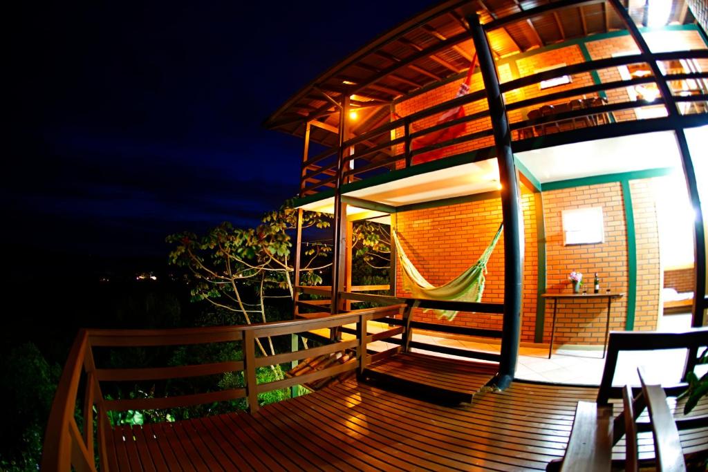 una casa con una hamaca en la terraza por la noche en Cabanas do Mirante, en Imbituba