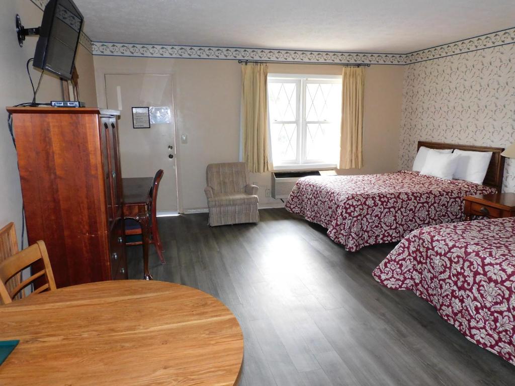 Habitación de hotel con 2 camas y mesa en Valley Inn - Hamilton Ga, en Hamilton