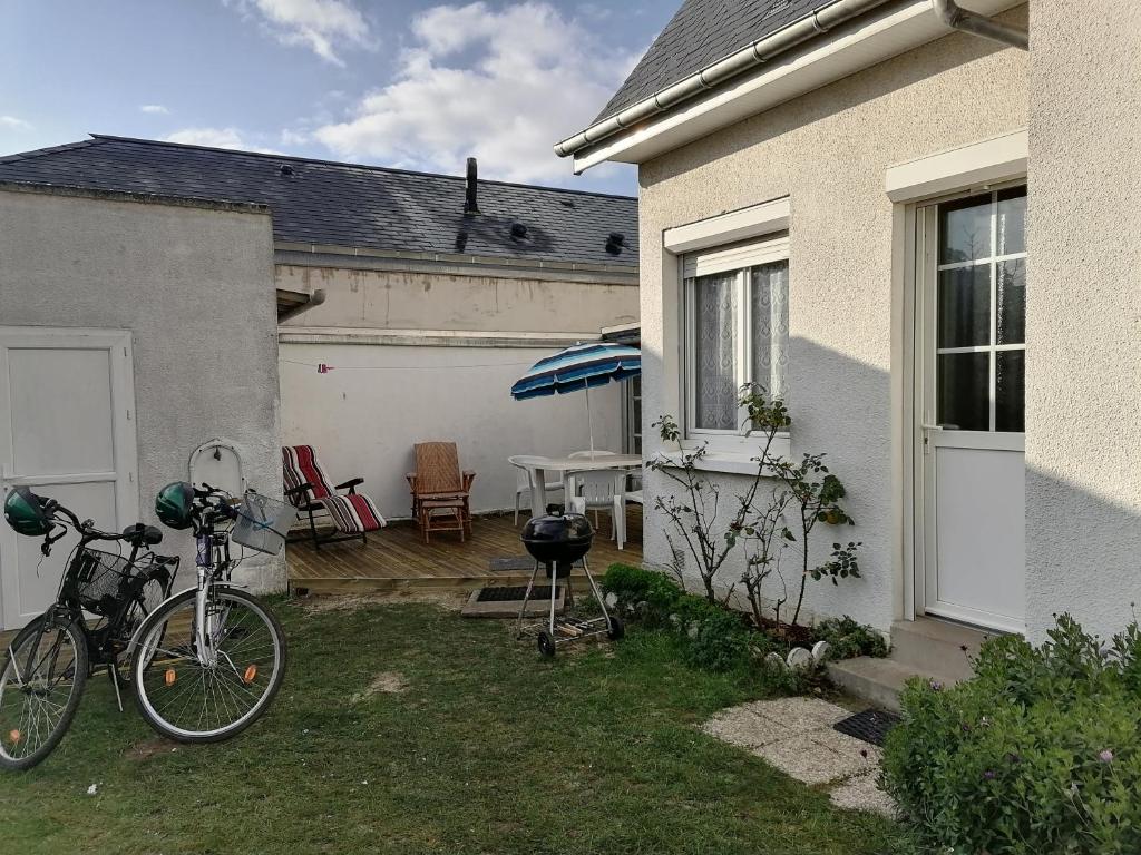 een fiets geparkeerd in een tuin naast een huis bij Studio Calme in Ouistreham