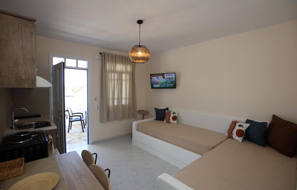 a bedroom with a bed and a living room at RESTIA in Agios Petros