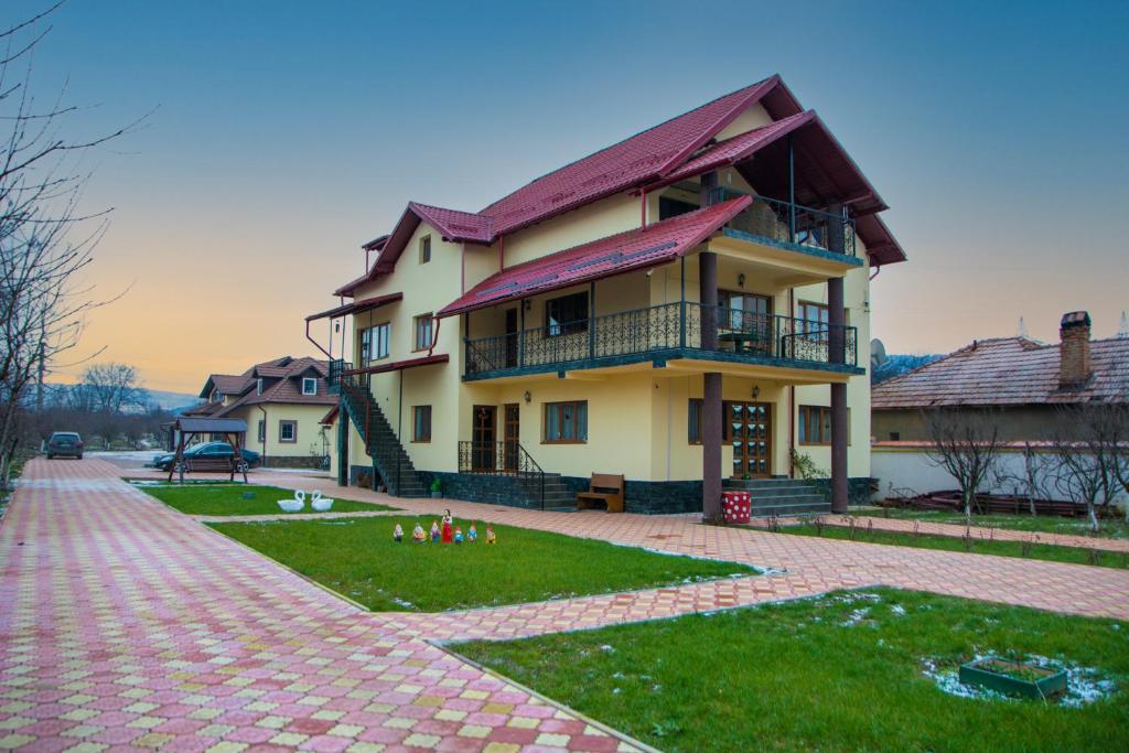 a house with a brick walkway in front of it at Casa Stefania 1 in Călimăneşti