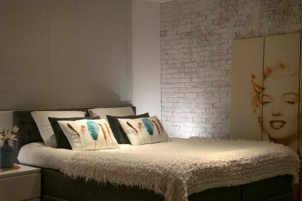 1 dormitorio con cama con almohadas y pared de ladrillo en B&B Sloterpark, en Ámsterdam