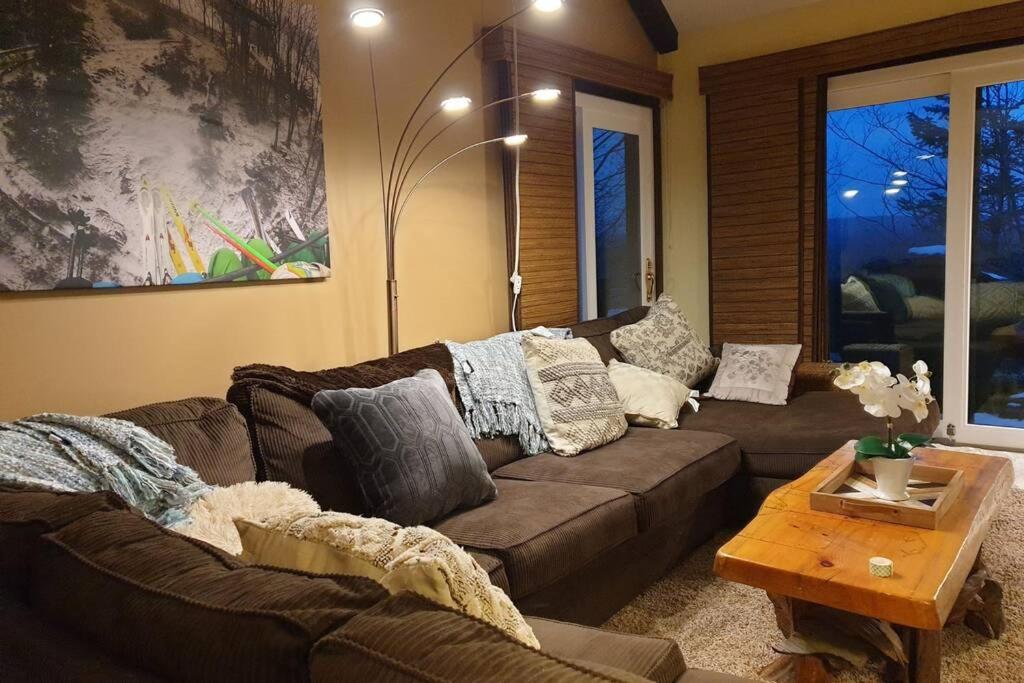 a living room with a brown couch and a table at 180 SKI CAMELBACK-SKI-ON -SKI OFF,SNOW TUBING,Paintball in Tannersville