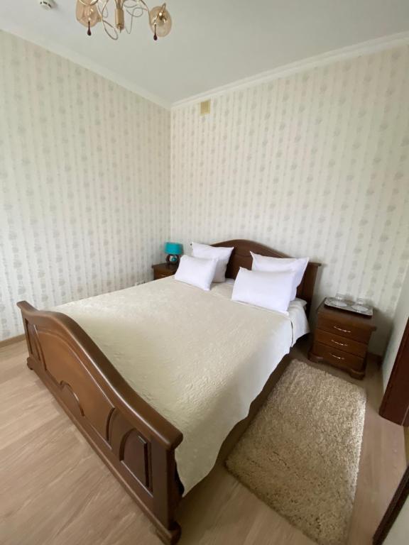 a bedroom with a large bed with white sheets and pillows at Motel in Sarny