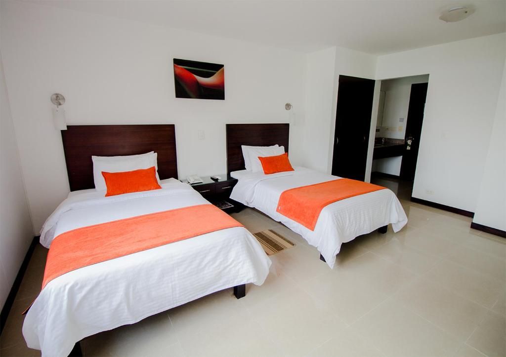 Postel nebo postele na pokoji v ubytování Hotel Pinares Plaza