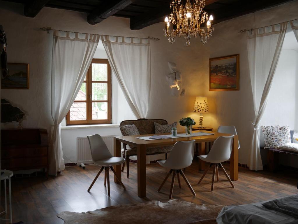 comedor con mesa, sillas y lámpara de araña en Appartement Donaustrand, en Bergern