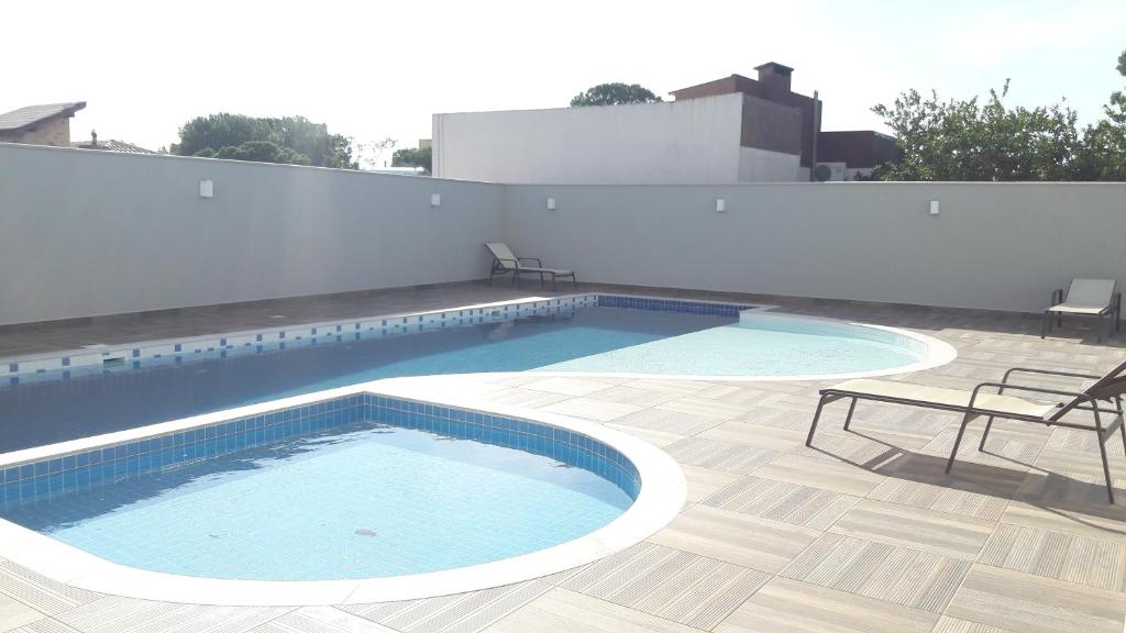 a swimming pool on the roof of a building at Florianópolis Canasvieiras Apartamento inteiro 3 quartos com ar piscina playground 2 garagens in Florianópolis