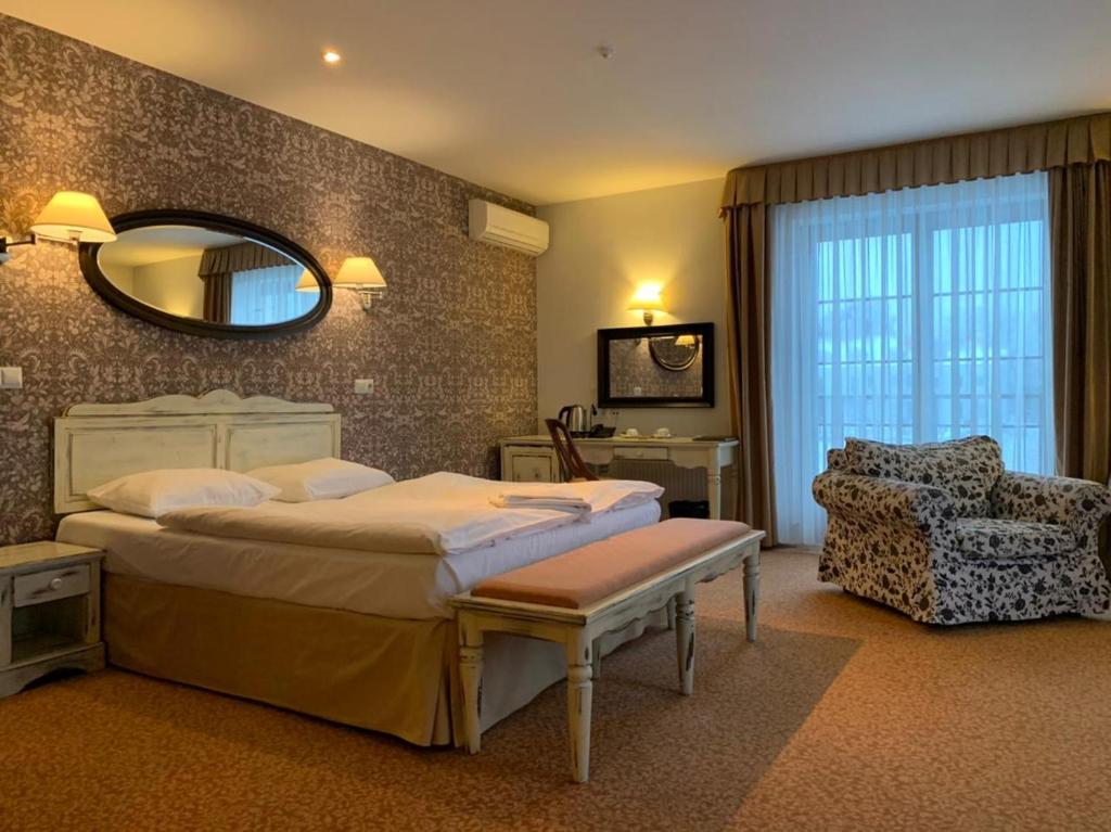a bedroom with a bed and a mirror and a chair at Hotel Usadba in Kaliningrad