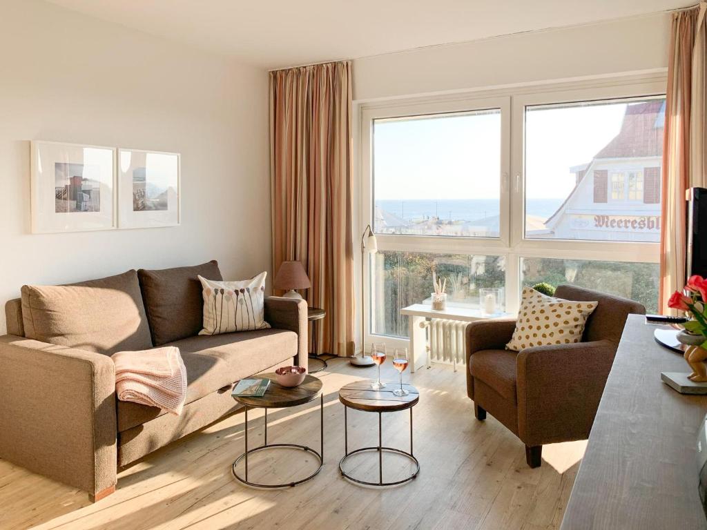 sala de estar con sofá y 2 sillas en Schloss am Meer, App 9, en Wenningstedt