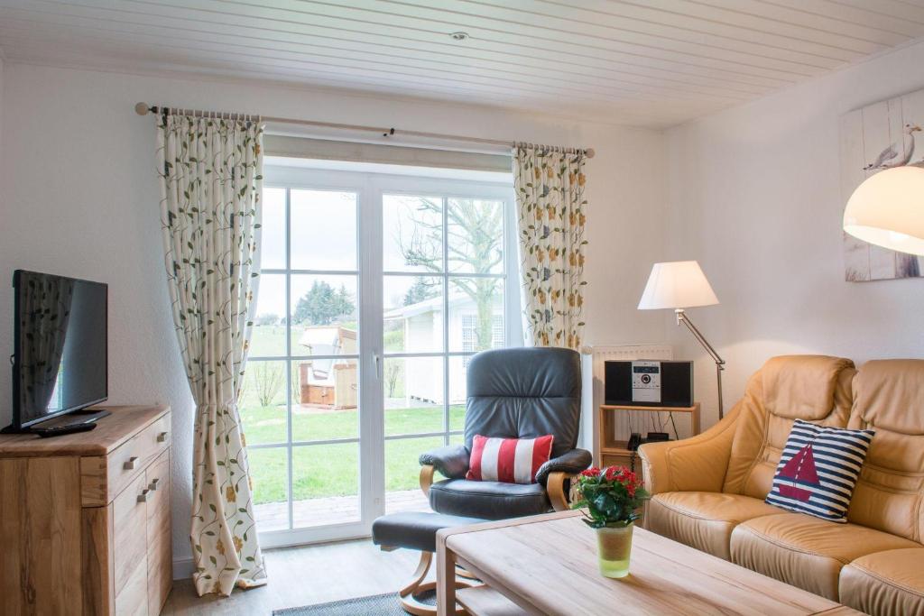 a living room with a couch and a chair at LH Westermüür, Hausteil 1 in Braderup