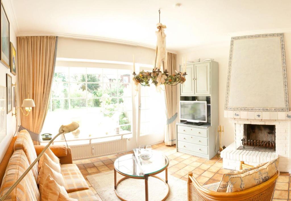 a living room with a couch and a fireplace at LH Westerhörn, App 1 in Wenningstedt