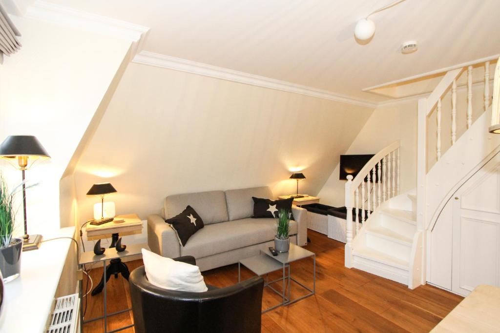 - un salon avec un canapé et un escalier dans l'établissement Inselfreude Whg 10, à Westerland