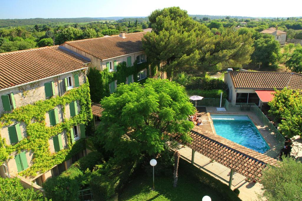 - une vue aérienne sur un bâtiment et une piscine dans l'établissement Logis Hotel Restaurant Uzès Pont du Gard, à Uzès