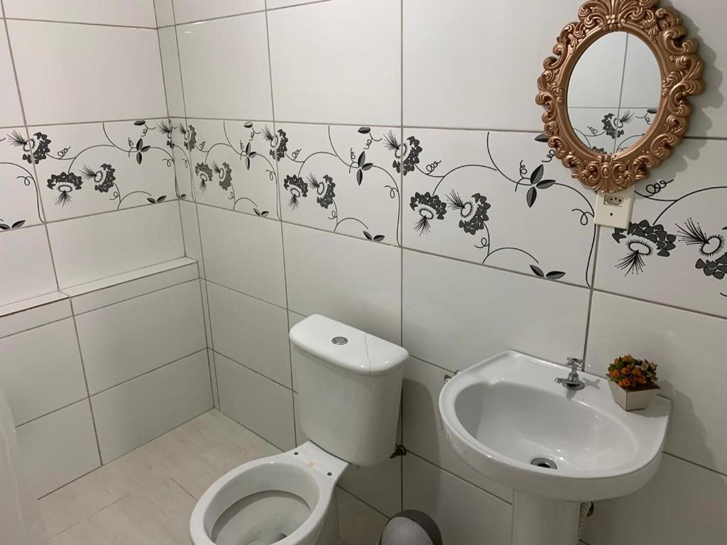 uma casa de banho com um WC, um lavatório e um espelho. em Kitnet - Apart Hotel 3 em Sete Lagoas