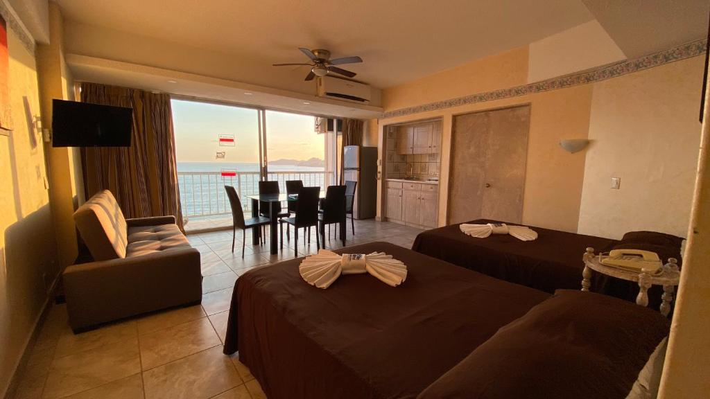 una camera d'albergo con due letti e un soggiorno di Hotel Las Torres Gemelas Acapulco ad Acapulco