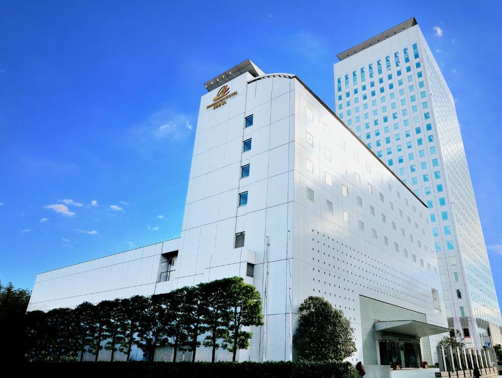 un grand bâtiment blanc avec un panneau sur celui-ci dans l'établissement Rembrandt Hotel Ebina, à Ebina