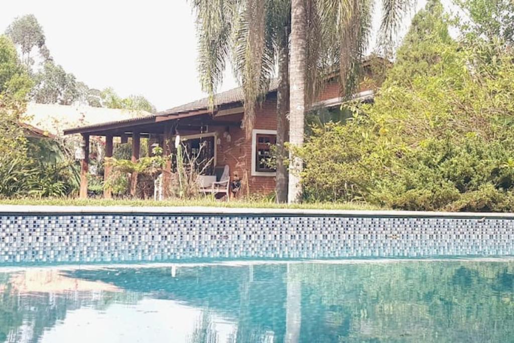 una casa con piscina frente a una casa en LINDA CHACARA EM CONDOM 30 MIN DE SP piscina climatizada, churrasqueira, wifi, 5 quartos, amplo jardim, en Cajamar