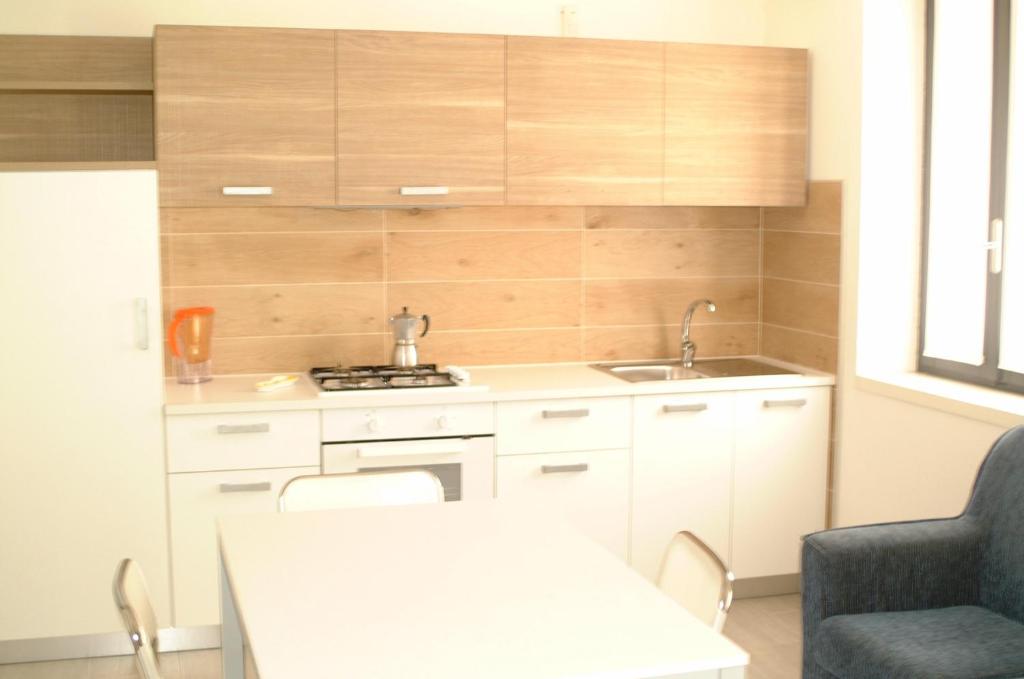 a kitchen with white cabinets and a table and a sink at Casa Maculan in Villaverla