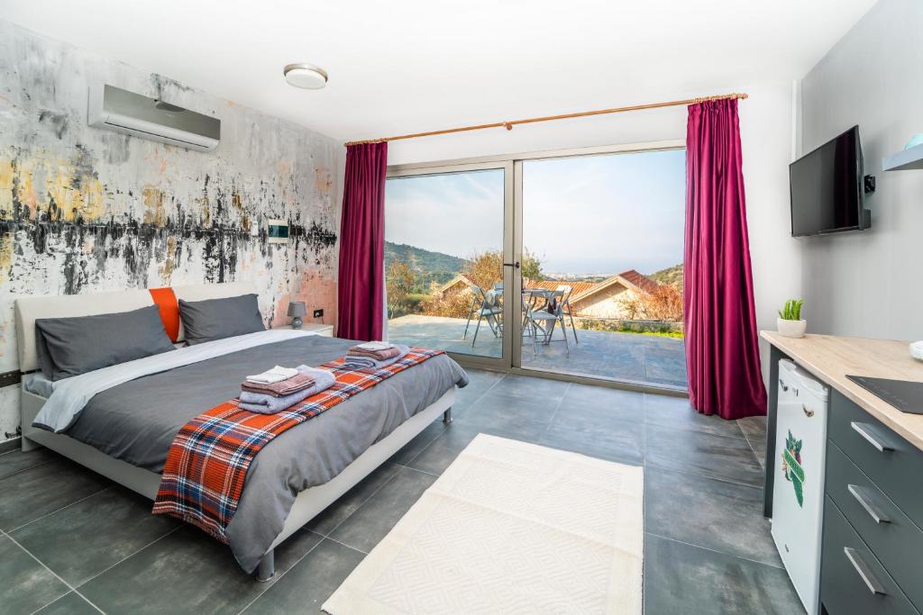 sypialnia z łóżkiem i dużym oknem w obiekcie Chardonnay Guest Studio Rooms with Great view for nature lovers w mieście Kirenia