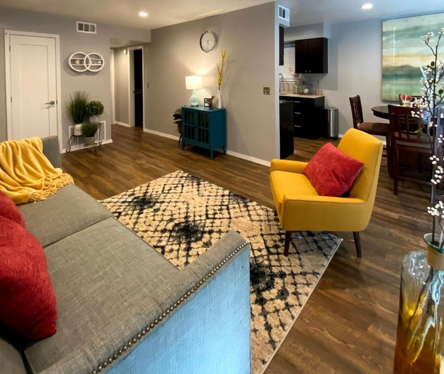 a living room with a couch and a yellow chair at Evie's Campus-close 2 bedroom luxury in Oklahoma City