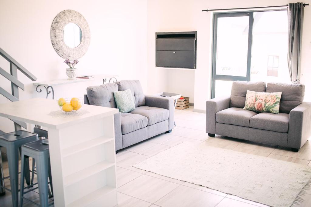 a white living room with a couch and a table at Oppikoppie Langebaan in Langebaan