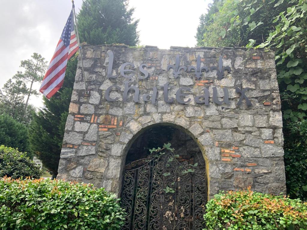 a gate in a stone wall with an american flag at Jackson’s Stone Mountain Hideaway in Stone Mountain