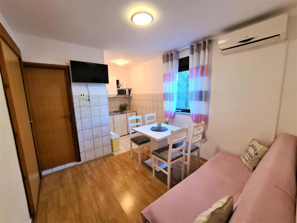 a small living room with a couch and a table at ĆOSIĆ APARTMANI IGRANE in Igrane