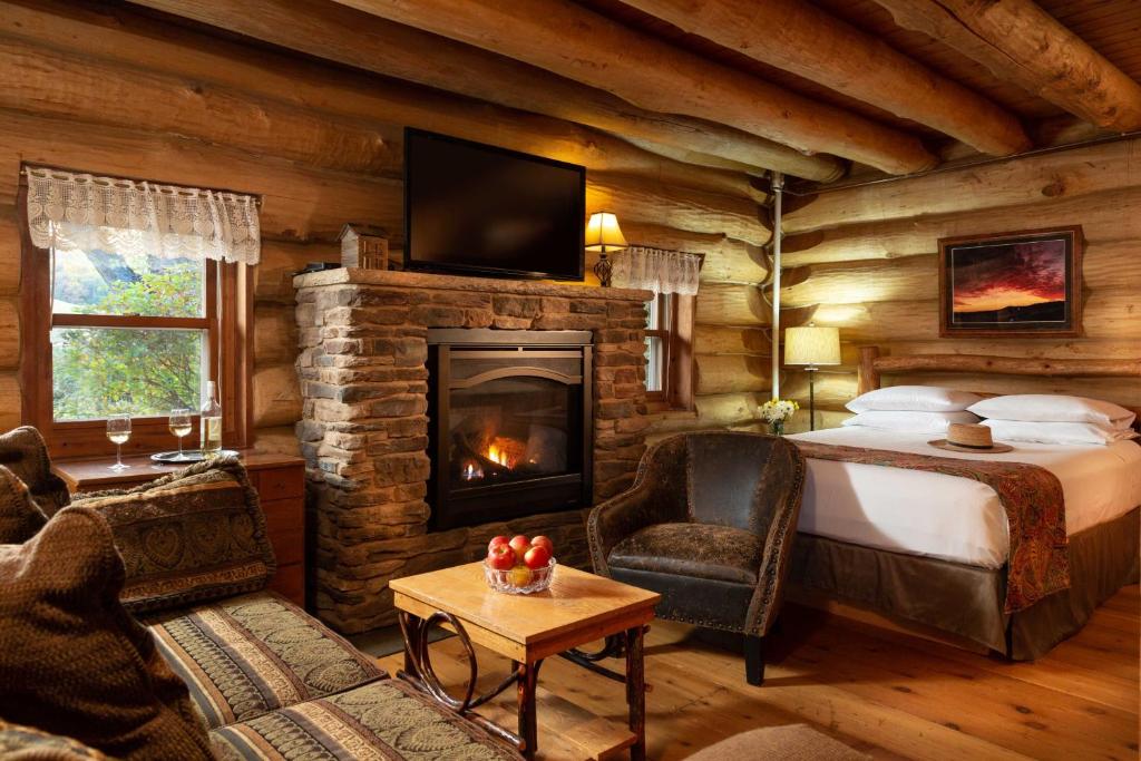 1 dormitorio con chimenea en una cabaña de madera en Justin Trails Resort, en Sparta